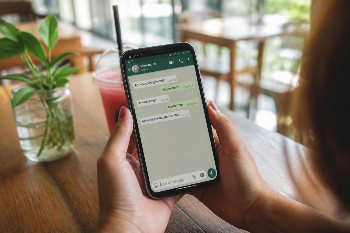 Hände halten ein Smartphone mit einem grünen Chatverlauf